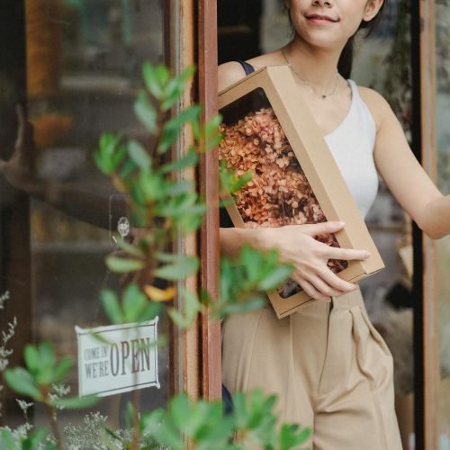 Photo by Amina Filkins on <a href="https://www.pexels.com/photo/crop-glad-woman-with-dried-flowers-box-leaving-floristry-store-5414059/" rel="nofollow">Pexels.com</a>